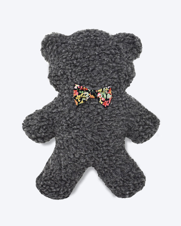 Plush Dog Toy filled with 100% organic lavender to help calm your pet. Wearing a black floral bowtie. Designed to give back 100%.