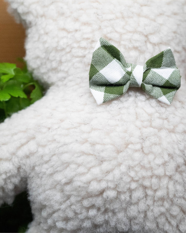 Plush Dog Toy filled with 100% organic lavender to help calm your pet. Wearing a green gingham bowtie. Designed to give back 100%.