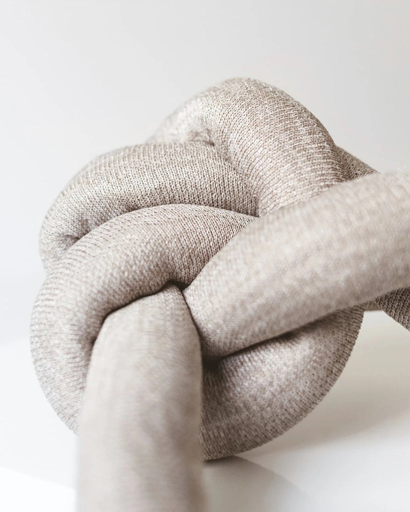 Tan NOUNOU by Lambwolf Collective. A long versatile toy tied into a knot.